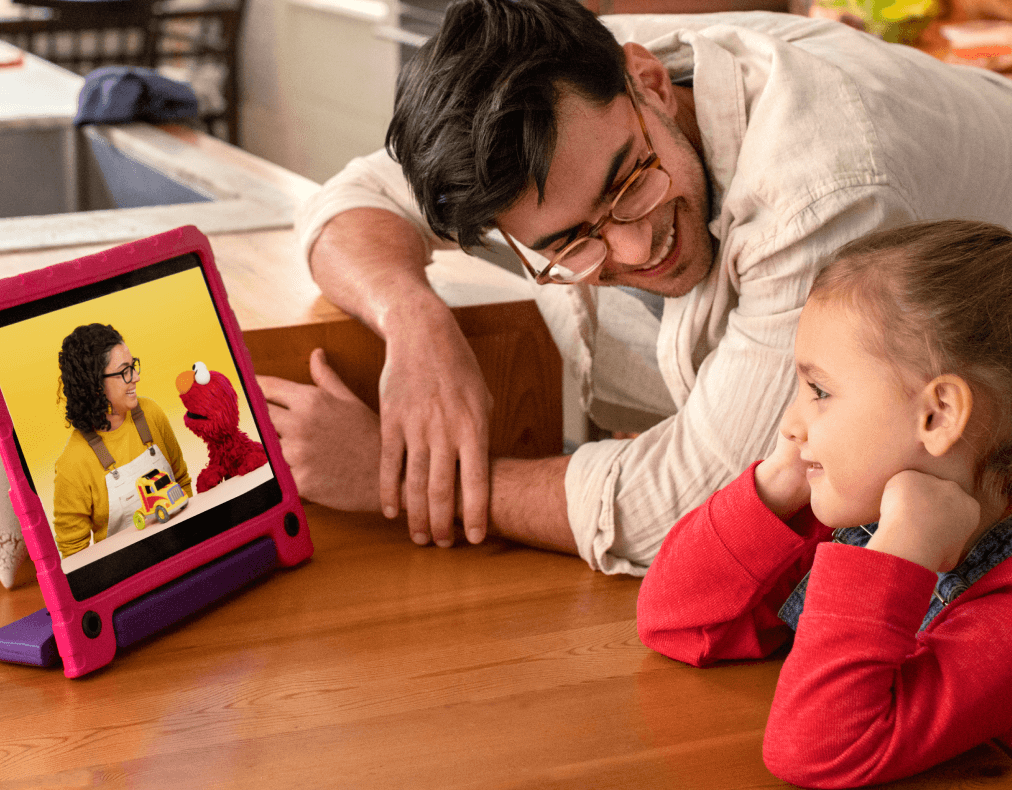 Grown up and child playing with Learn With Sesame Street app